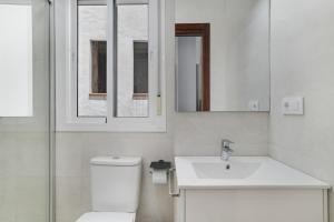 a bathroom with a toilet and a sink and a mirror at Juani en Conil in Conil de la Frontera +13 photos