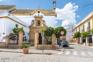 un vieux bâtiment dans une rue avec une église dans l'établissement Santa Clara Home, à Marchena