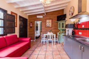 a kitchen with a red couch and a table at El Capricho de Rosmary in Villanueva +16 photos