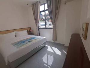 a small bedroom with a bed and a window at Khamsay Hotel in Vientiane
