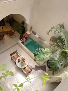 an overhead view of a pool in a living room with a man standing next to at Riad Dar Amazonia in Marrakech