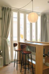 una cucina con un bar con due sgabelli e alcune finestre di The Dates Villa ad Ho Chi Minh