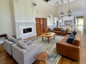 Una sala de estar con dos sofás y una chimenea. en Bergzicht Villa, en Swellendam