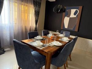 a wooden table with chairs and a dining room at Sazeesha Apartments in Ndola