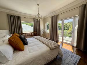Un dormitorio con una cama grande y una ventana grande en Bergzicht Villa, en Swellendam 29 fotos más