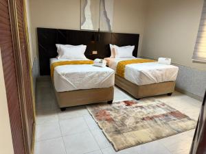 Un dormitorio con dos camas y una alfombra. en Sazeesha Apartments, en Ndola