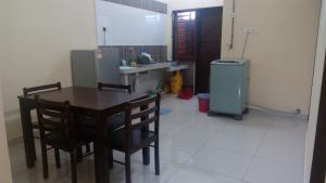 a kitchen with a table and chairs and a refrigerator at Taiping Valuable Homestay in Taiping