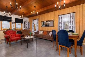 ein Wohnzimmer mit einer Couch und einem Tisch und Stühlen in der Unterkunft Spacious House For Families Szczyrk in the Mountains by Noclegi Renters in Szczyrk