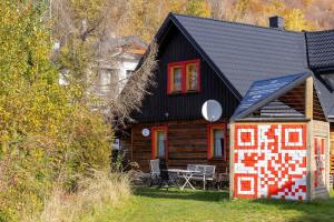 eine Blockhütte mit einem Tisch und Stühlen davor in der Unterkunft Spacious House For Families Szczyrk in the Mountains by Noclegi Renters in Szczyrk + 27 Fotos