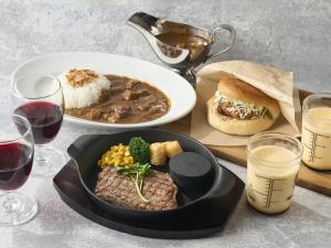 una mesa con un plato de comida, un tazón de sopa y un sándwich en ホテル フェスタ 葉山, en Hayama