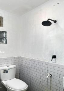 a white bathroom with a toilet and a light at Rahayu Cabin Villa in Dieng