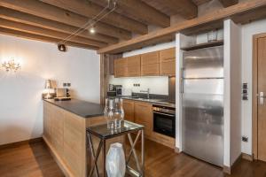 a kitchen with wooden cabinets and a stainless steel refrigerator at Apartment Aelora Courchevel - by EMERALD STAY in Courchevel +36 photos