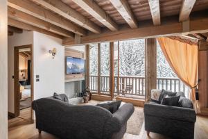 a living room with two couches and a large window at Apartment Aelora Courchevel - by EMERALD STAY in Courchevel