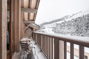 a balcony with a chair and a view of a city at Apartment Aelora Courchevel - by EMERALD STAY in Courchevel