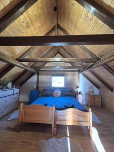 a bedroom with a blue bed in a attic at Kuća Šarenka in Kupjak