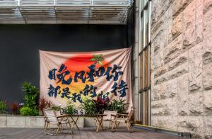 深圳Sentraland Pengyue Garden International Hotel Shenzhen Futian Shangmeilin Metro Station Branch的建筑物侧面挂着横幅，旁边放着椅子。 更多29张照片