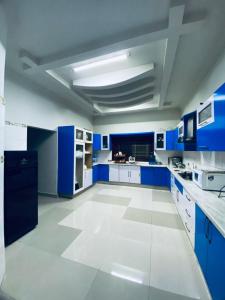 a blue and white kitchen with blue cabinets and appliances at Seaview Luxury Hotel in Karachi