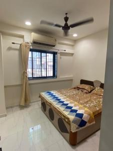 a bedroom with a bed and a ceiling fan at Citizen Society, Ellora Park, is very peaceful in Vadodara