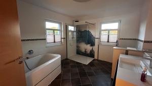 un bagno con vasca, doccia e lavandino di Ferienwohnung Zahn a Markersbach Altre 10 foto