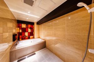 a bathroom with a bath tub and a shower at Hotel Lotus Yokohama in Yokohama +14 photos