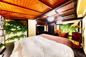 a bedroom with a bed and a desk with a lamp at Hotel Lotus Yokohama in Yokohama