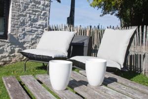 two white pillows and a chair on a wooden table at Le Nid de la Gotale in Manhay