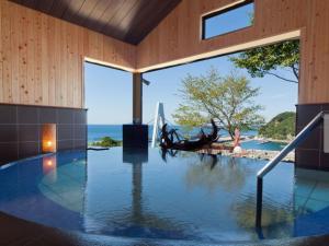 ein Swimmingpool in einem Haus mit Blick auf das Meer in der Unterkunft Isaribinoyado Seaside Kancho in Wakayama