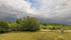 ein Spielplatz auf einem Feld unter einem bewölkten Himmel in der Unterkunft Apartment für Drei 44 in Stedar
