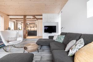 een woonkamer met een bank en een tv bij Sylter Strandholz in Westerland