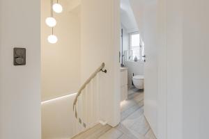 een witte badkamer met een wit bad en een toilet bij Sylter Strandholz in Westerland +31 foto's