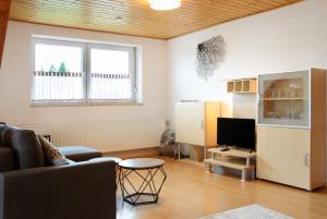 a living room with a couch and a tv at Wohnung Karin in Spalt