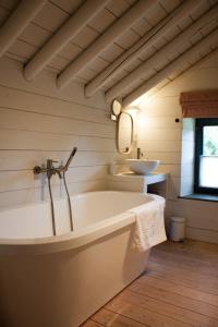 a white bathroom with a tub and a sink at Le Nid de la Gotale in Manhay +3 photos