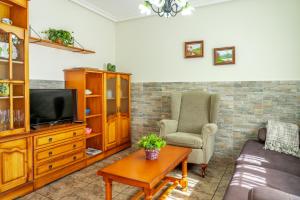 a living room with a couch and a tv at Casa Monterriundo I y Apartamento Monterriundo II in Candás