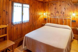 a bedroom with a bed in a wooden room at Casa Monterriundo I y Apartamento Monterriundo II in Candás
