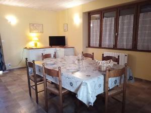 a dining room table with chairs and a white table cloth at Gîte de Goutrens in Goutrens
