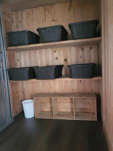a wooden shelf with bowls and baskets on it at Ryokan Kume Himawari Sou in Sakaide +1 photo
