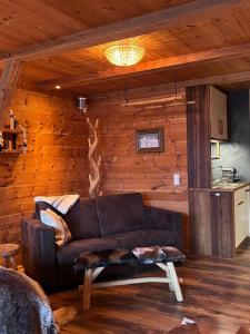 a living room with a leather couch in a log cabin at Chalet Gipfelblick Inzell in Inzell