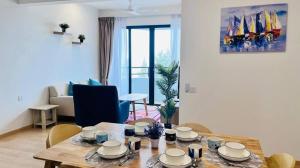 ein Wohnzimmer mit einem Holztisch mit Stühlen in der Unterkunft Mutiara Melaka Beach Resort in Malakka