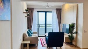 ein Wohnzimmer mit einer Couch und einem Schreibtisch mit einem Fernseher in der Unterkunft Mutiara Melaka Beach Resort in Malakka