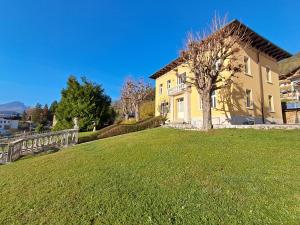a yellow house with a tree in a yard at Villa Emilia nelle Dolomiti in Domegge di Cadore +22 photos