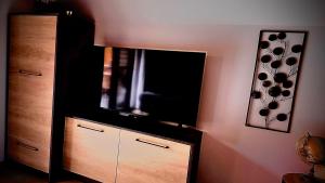 a flat screen tv sitting on top of a dresser at Tiszaparti Meseház in Tiszalök