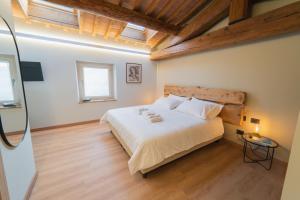 a bedroom with a large white bed with a wooden headboard at Corte Bonfiglio Colombari in Illasi