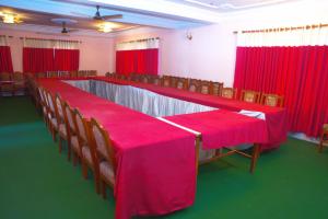 PokharaにあるHotel Lake Palaceの赤いカーテン付きの部屋のテーブルと椅子