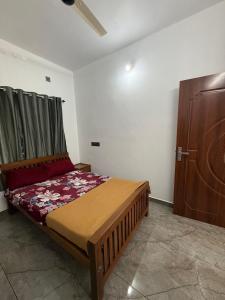 Un dormitorio con una cama y un armario. en Varghese staycation, en Ernakulam