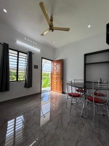 Un comedor con mesa y sillas y un ventilador de techo. en Varghese staycation, en Ernakulam