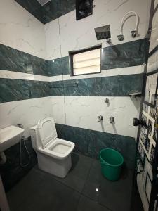 un baño con inodoro y lavabo en Varghese staycation, en Ernakulam