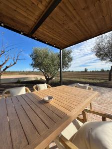 a wooden table and chairs under a wooden roof at Mas Les Arrabassades in Castelló d'Empúries