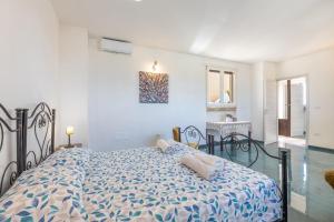 a bedroom with a bed with a blue and white comforter at Palazzo Lily in Racale