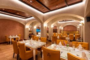 een restaurant met witte tafels en gele stoelen bij Jajati Courtyard in Jajpur Road