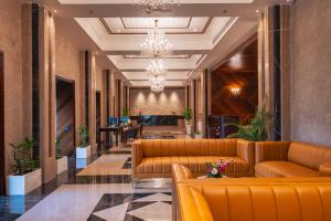 a lobby with leather couches and a chandelier at Jajati Courtyard in Jajpur Road